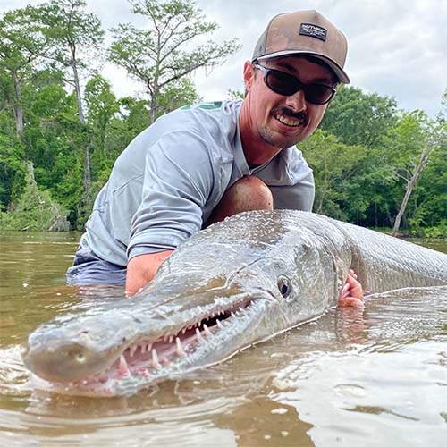 Biologist holding an alligator gar