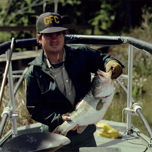 Old GFC biologist holding a bass
